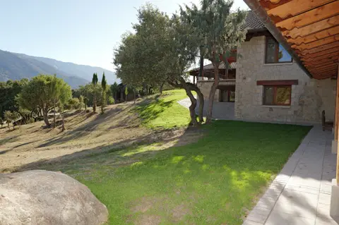 Lateral de la casa, con césped y vistas a la sierra