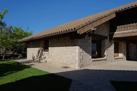 Otra vista de la casa de piedra junto al césped