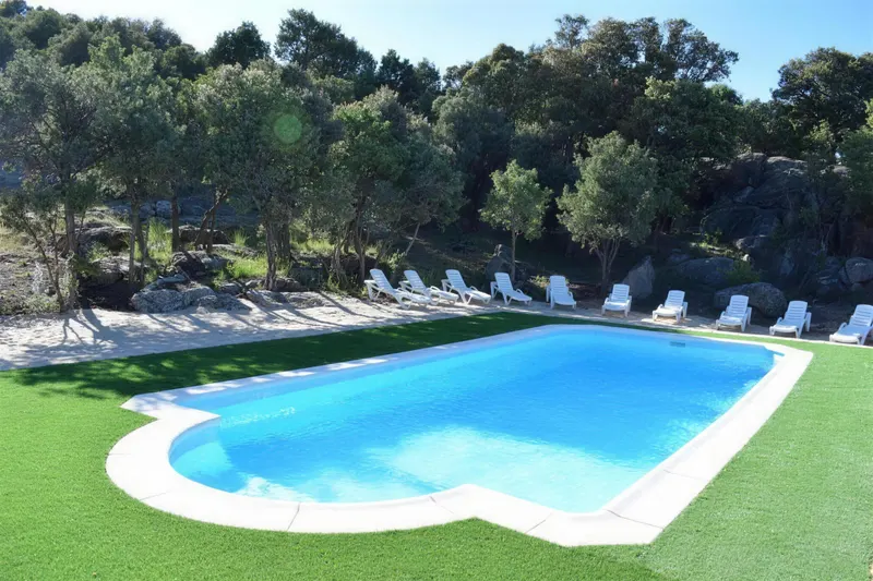 Piscina de 10 × 4 m con césped y tumbonas