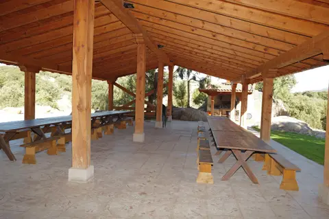 Mesas y bancos de madera maciza en el porche