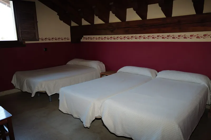 Habitación amplia bajo vigas de madera