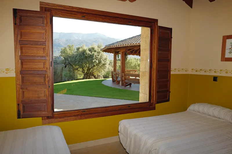 Habitación con ventana al jardín y la sierra
