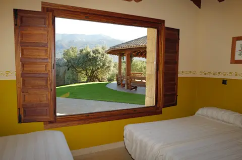Habitación con ventana al jardín y la sierra